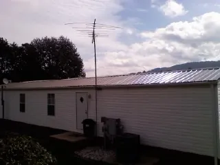 New metal roof on a single wide mobile home with a TV antenna in Pownal