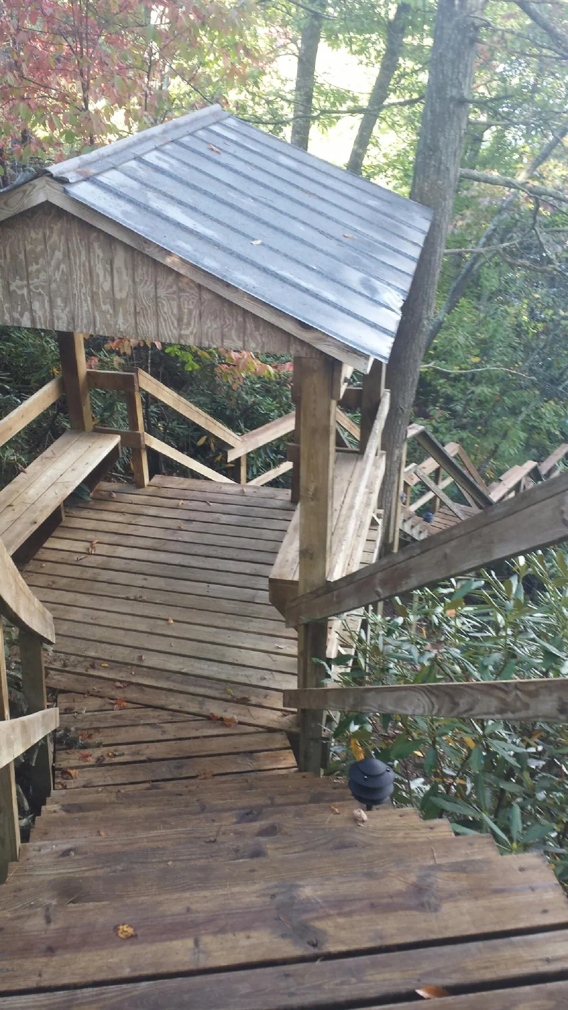 Metal roofed shelter over wooden steps on a wooded walkway — Skylight Repair & Installation work by our crew in Pownal