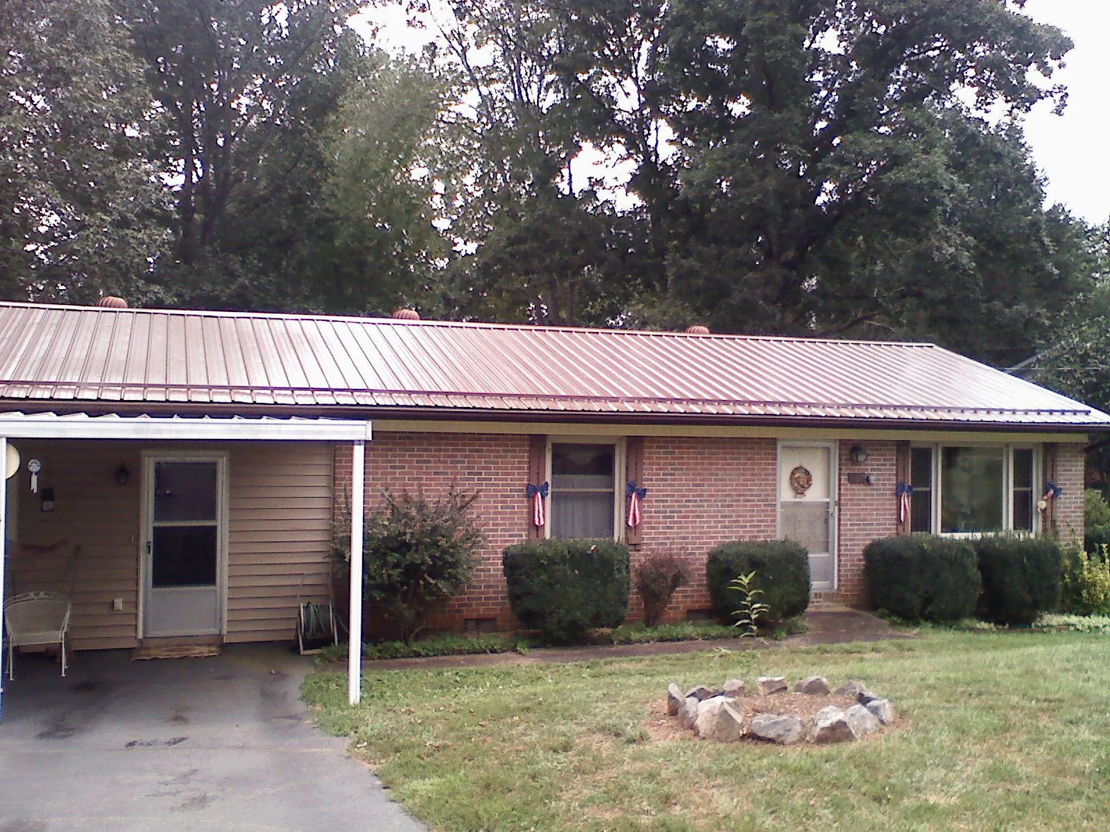 Bronze metal roof and carport on a brick ranch home — Roof Repair work by our crew in Pownal